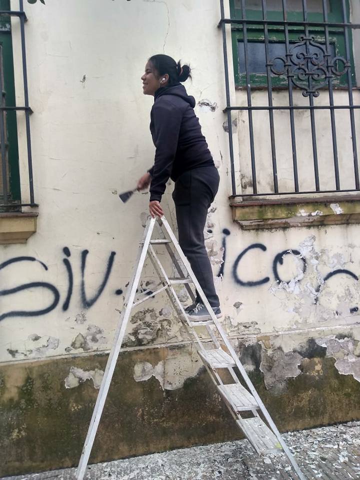 Socias de cooperativa del estacionamiento medido arreglan edificio del correo